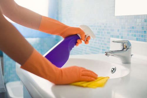 Local cleaner preparing a furnished bedroom for new guests